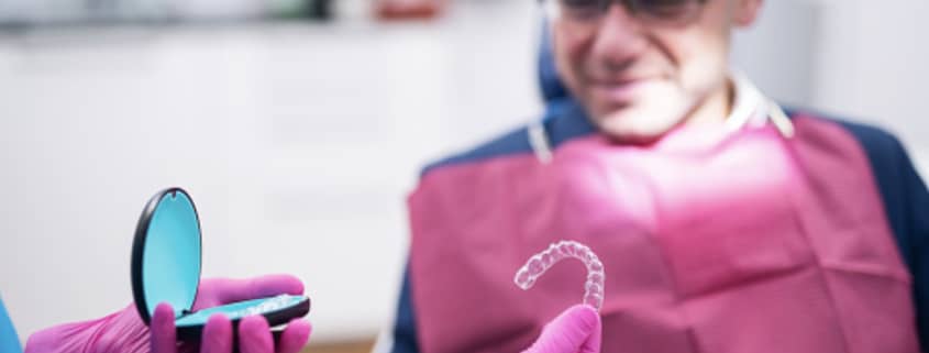 Alignment Matters: Straighter Teeth For Better Health 1 Dentist Giving Dental Aligners To A Patient.