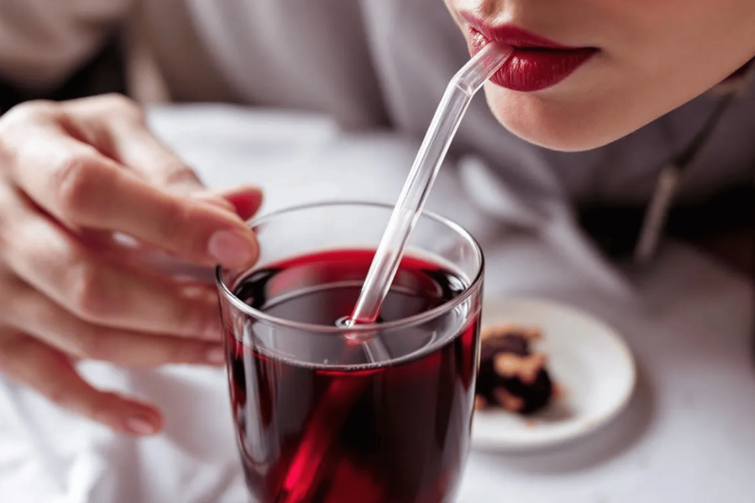 A Person Is Sipping A Beverage Through A Straw To Reduce Contact Between The Drink And Their Teeth, Aiming To Prevent Tooth Discoloration And Maintain A Bright Smile.