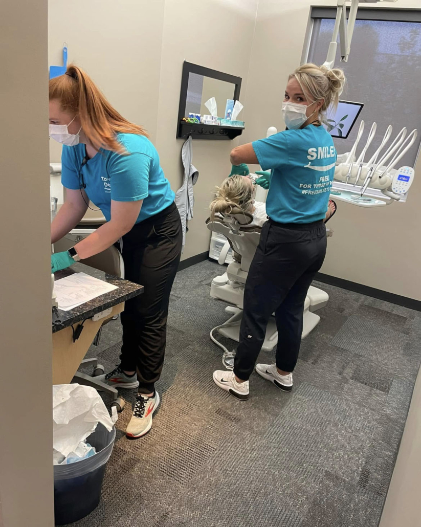 Dentist Working On Patient With Dental Assistant